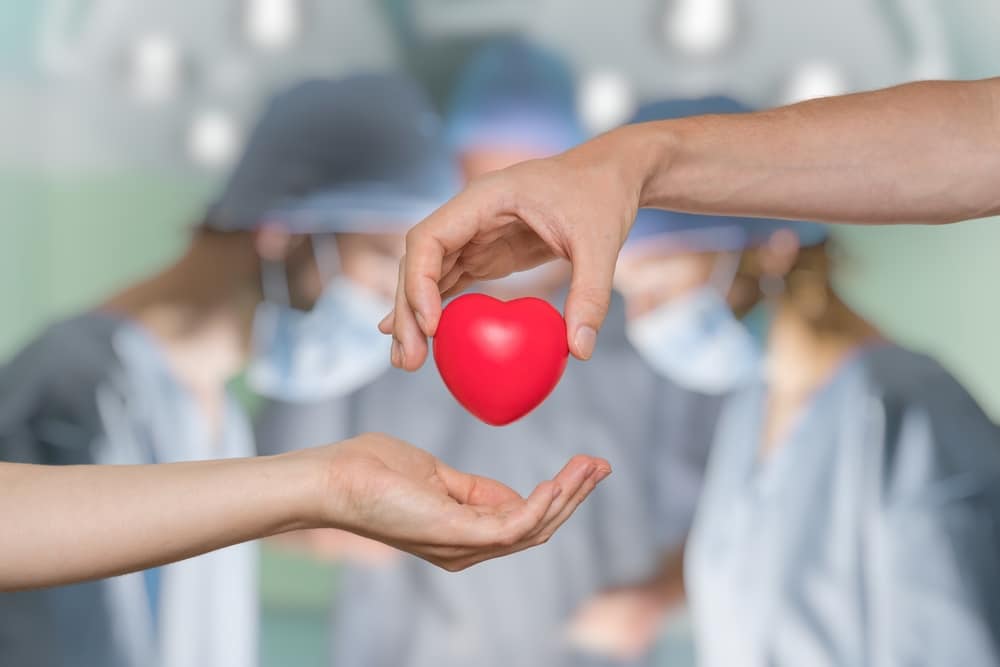 A cosmetic dentist, Dr. Sean Endsley, is holding a red heart in their hands.