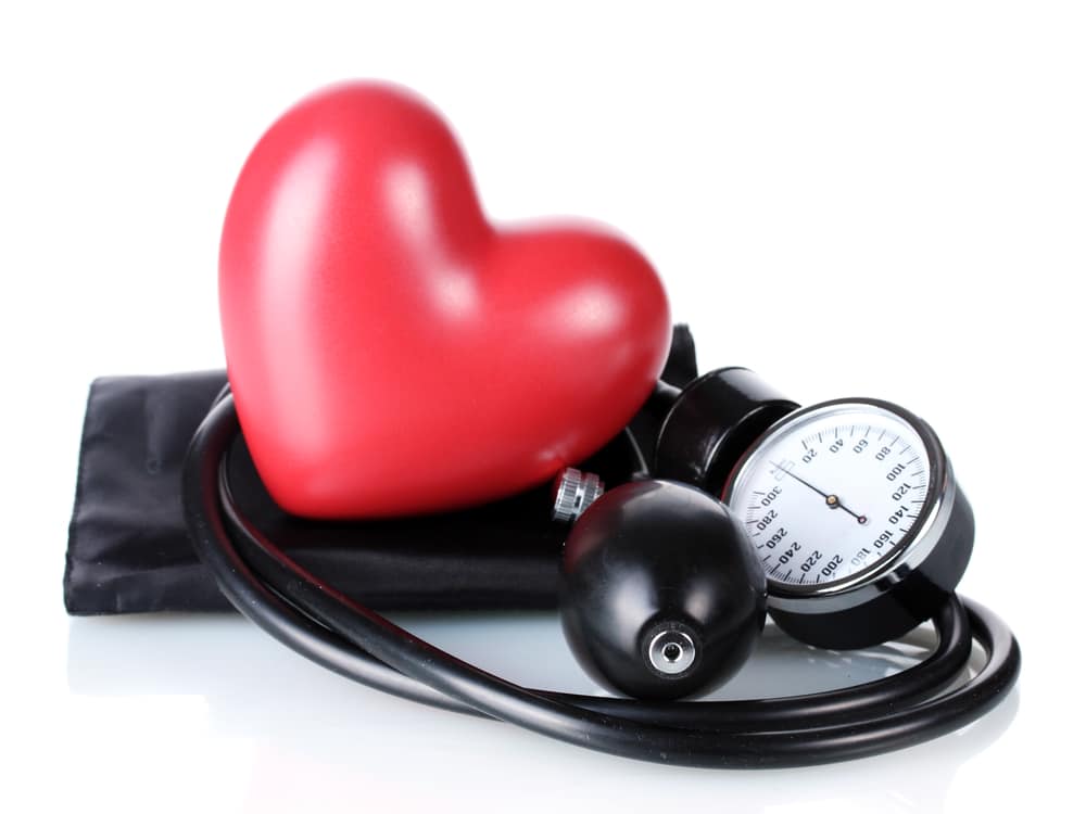 A red heart and a blood pressure sphygmomanometer on a white background with Dr. Sean Endsley, cosmetic dentist