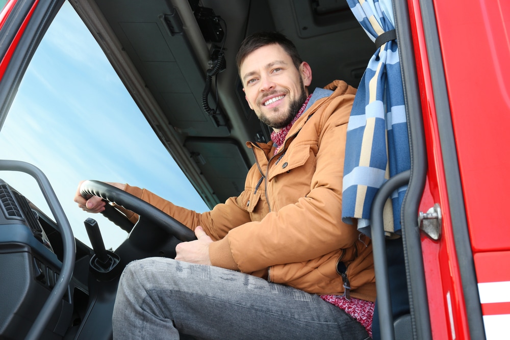 A man sitting in the driver's seat of a truck.