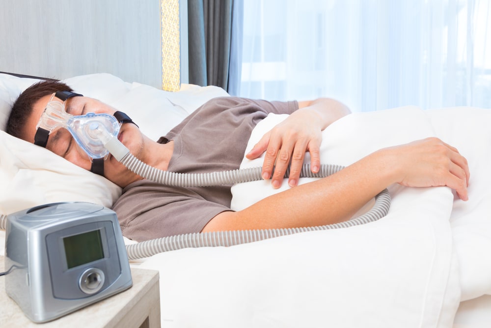 Dr. Sean Endsley, a general dentist, is sleeping in bed with a cpap machine.