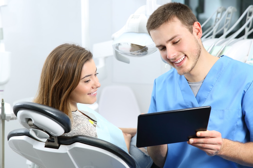 A man and a woman looking at a tablet in Dr. Sean Endsley's dental office.
