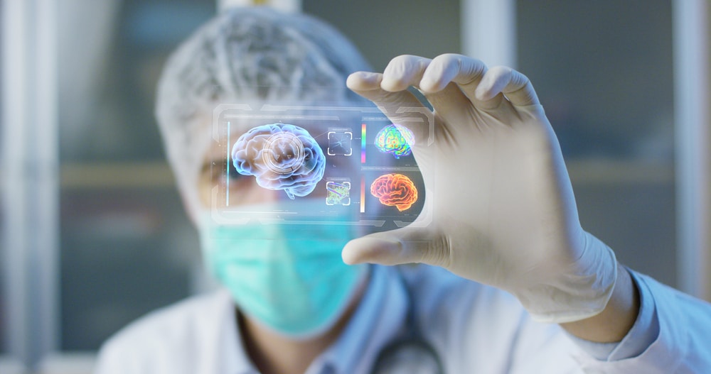 A doctor is holding up a virtual image of a patient's brain.