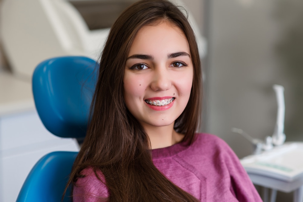 A young woman smiling in a dental chair at a waco dentist.