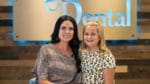 A woman and a girl posing in front of a dental sign along with Dr. Sean Endsley, a general dentist.
