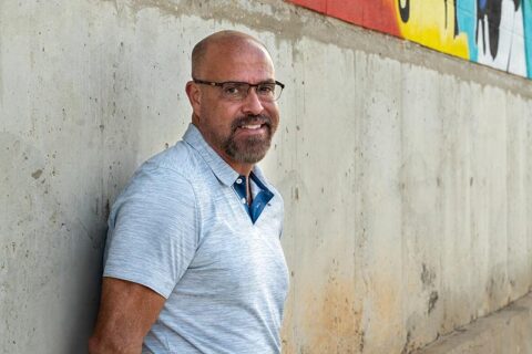 a man standing near the wall smiling