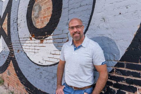 a man standing near the wall smiling