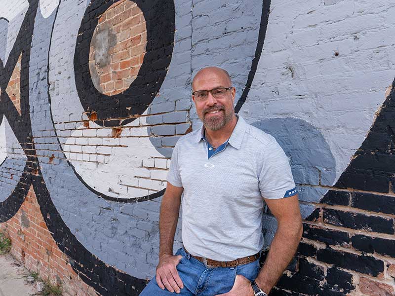 a man standing near the wall smiling