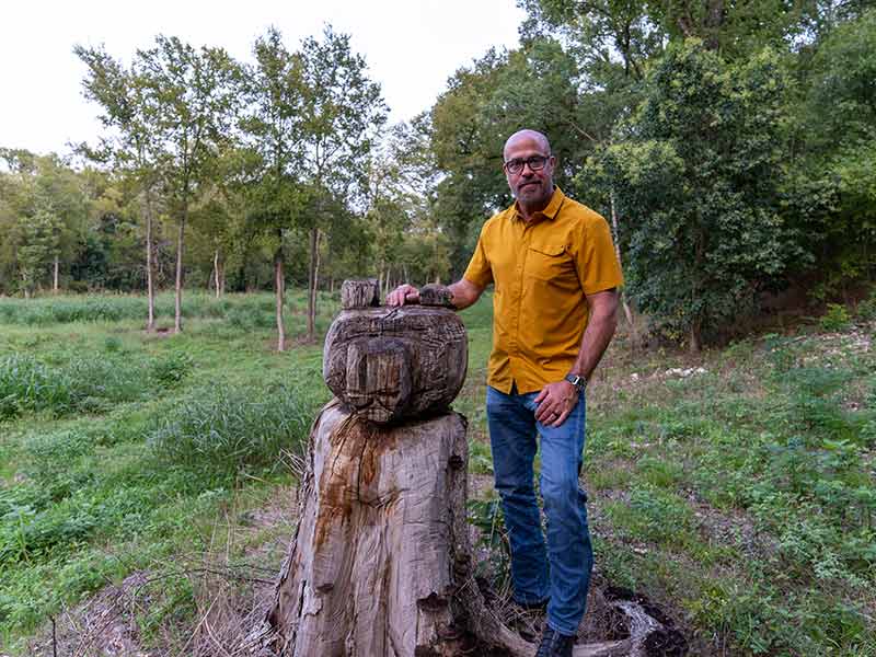 a man standing near a tree stump