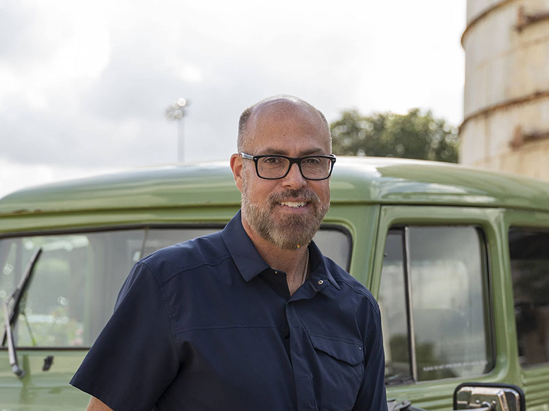 a man smiling standing near a car