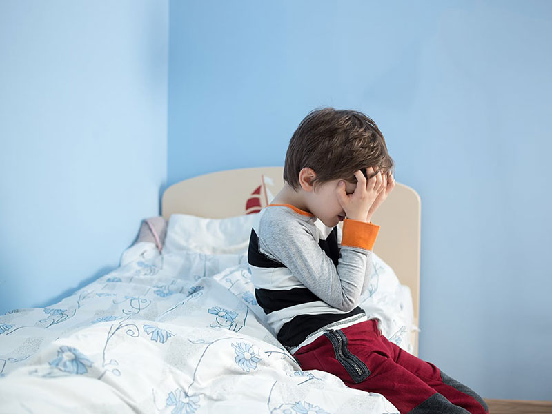 a boy holding his head