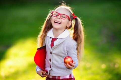 Cute girl smiling with an apple