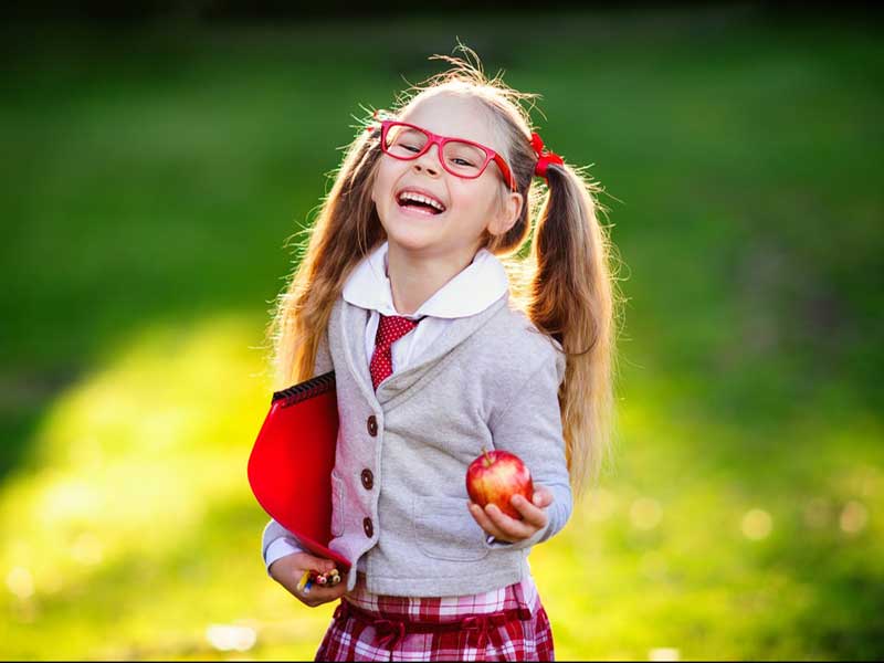 Cute girl smiling with an apple