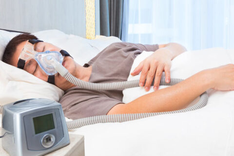 A person sleeping with sleep apnea equipment