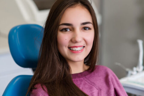 a young woman with braces on teeth smiling