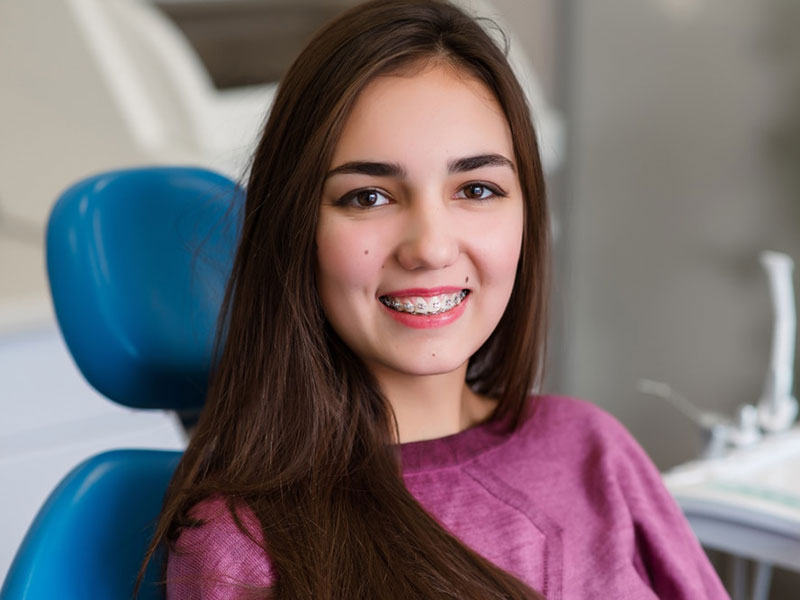 a young woman with braces on teeth smiling